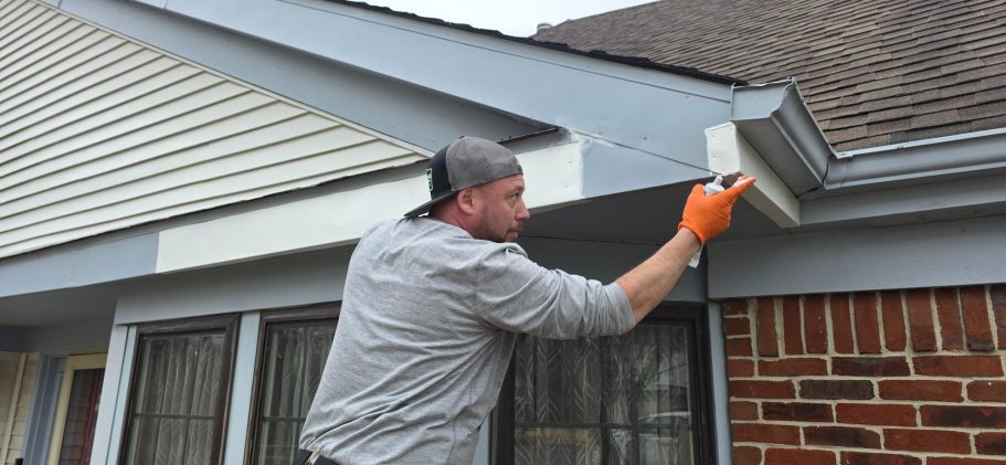 Maintenance technician repairing gutters and fascia.